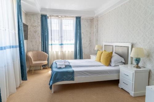 a bedroom with a bed with blue curtains and a window at Vila 18 Hotel Boutique in Bucharest