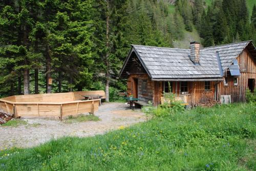 a log cabin with a hot tub in front of it at Hotel Zum Granitzl in Mariapfarr