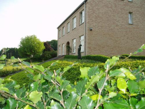 a brick building with a statue in front of it at B&B Vallis Dyliae in Korbeek-Dijle