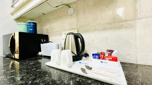 a kitchen counter with a coffee maker on a table at BluO 3BHK Safdarjung Enclave, Lift & Terrace Garden in New Delhi