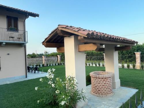 a wooden roofed pergola next to a house at La Porta delle Meraviglie in Saluzzo
