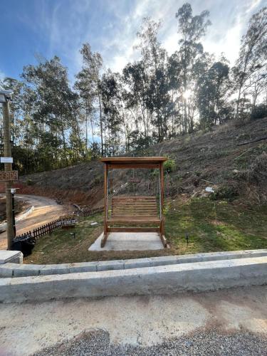 a bench sitting on the side of a road at Chalés do vale Extrema vermelho in Extrema