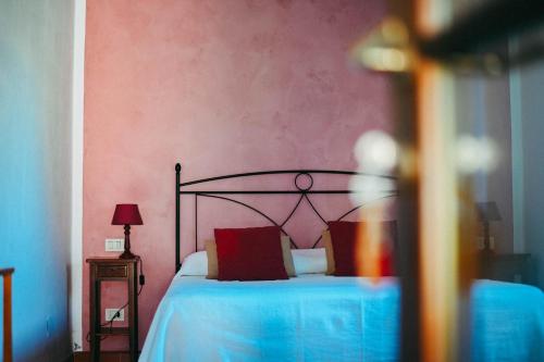 a bedroom with a bed with red pillows at Agriturismo Vallerana in Capalbio