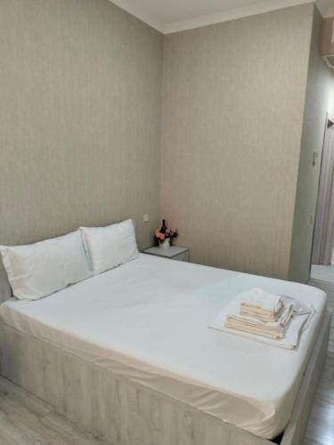 a bedroom with a white bed with towels on it at SKY Hotel Old Tbilisi in Tbilisi City