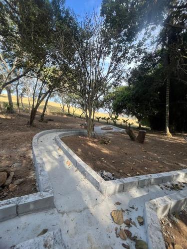 a concrete path in a park with a tree at Chalés do vale Extrema vermelho in Extrema