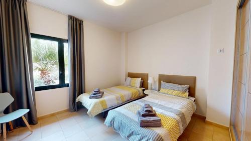 two beds in a room with a window at Casa Malasia M-Murcia Holiday Rentals Property in Fuente Alamo
