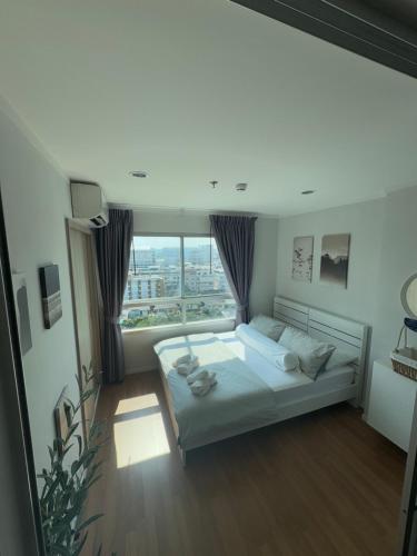 a bedroom with a bed and a large window at Minimalist Condo in Pinklao in Bangkok