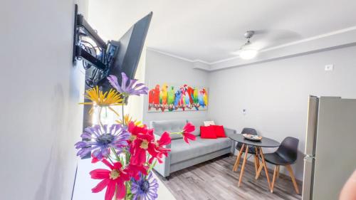 a living room with a couch and a table with flowers at At Piazza Erbe free parking Residenza Santa Anastasia in Verona