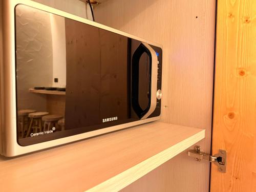 a microwave oven sitting on a shelf on a wall at Il bosco di Fiemme in Predazzo