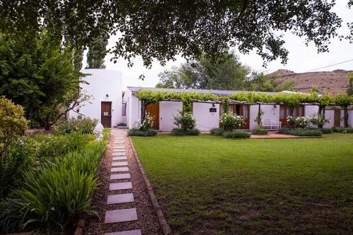 a white house with a garden and a lawn at Vygeboom Studio in Nieu-Bethesda