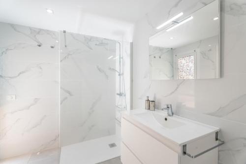 a white bathroom with a sink and a shower at Apartamento Afirama 1 in Araya