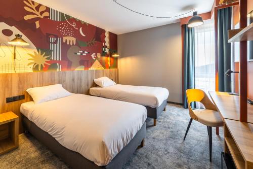 a hotel room with two beds and a desk at DeSilva Inn Opole in Opole