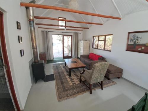 a living room with a couch and a table at Kleinwatervalplaas Farm Stay Accomodation in Caledon