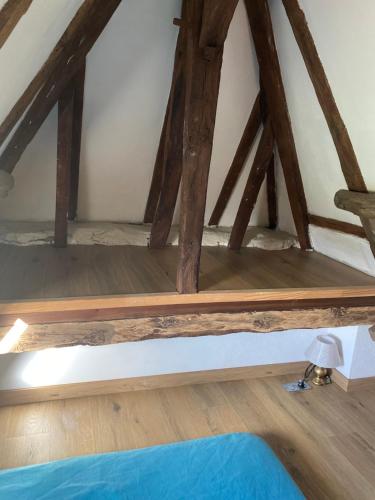 a wooden shelf in a attic with wooden beams at Les Carillons du Bois de l'Orme in Les Pechs-du-Vers