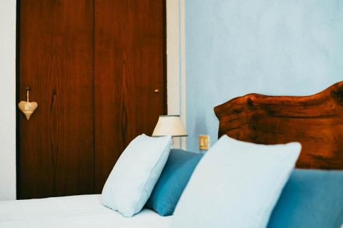 a bedroom with a bed with a wooden headboard and pillows at Agriturismo Vallerana in Capalbio
