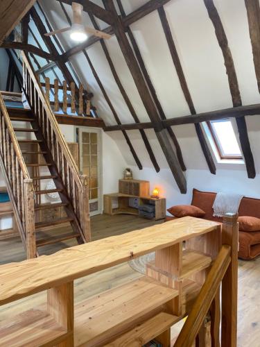 a large living room with wooden floors and wooden beams at Les Carillons du Bois de l'Orme in Les Pechs-du-Vers