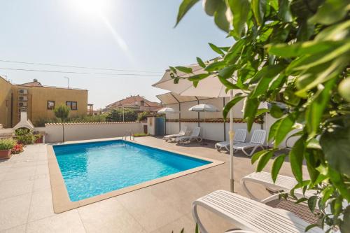 a swimming pool in a yard with chairs and an umbrella at Casa Fabris with Pool in Umag