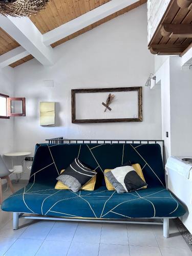 a blue couch in a living room with a clock on the wall at Apartamento Nido in Cáceres