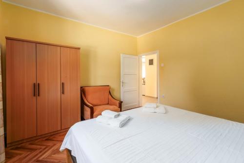 a bedroom with a white bed and a chair at Casa Fabris with Pool in Umag