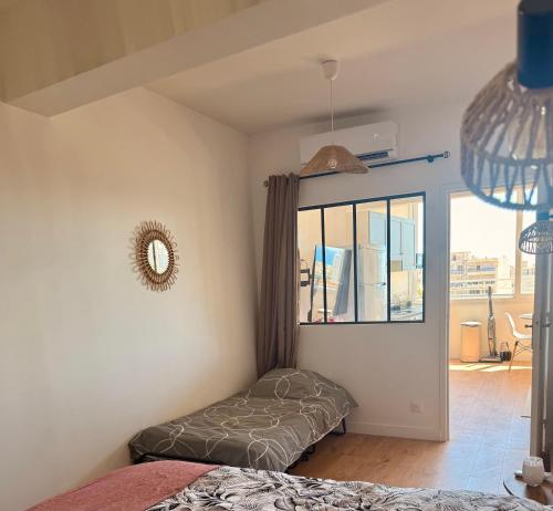a bedroom with a bed and a large window at Votre grand COCON Niçois Appart Vue Mer in Nice