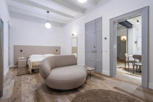 a living room with a chair and a bed at Old Theatre Suites - Favignana in Valletta