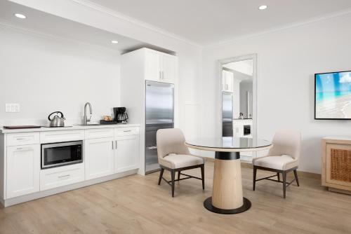 a kitchen with white cabinets and a table and chairs at Alexandra Resort - All-Inclusive in Grace Bay