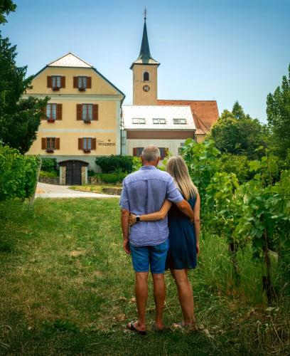 a man and a woman standing in front of a building at Dvorec Jeruzalem in Ivanjkovci