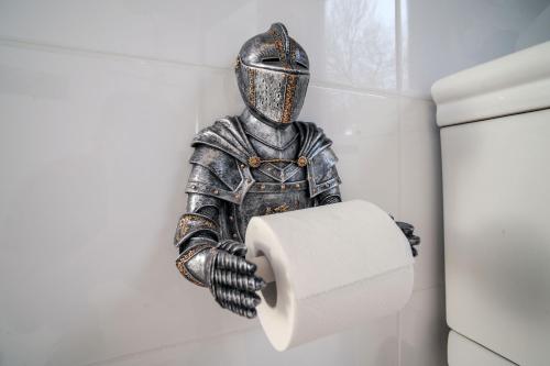 a statue of a knight holding a roll of toilet paper at Ferienwohnungen Traumschloss in Wernigerode