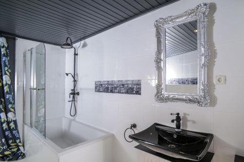 a bathroom with a black sink and a mirror at Ferienwohnungen Traumschloss in Wernigerode