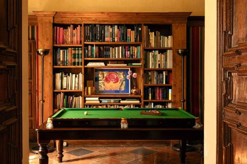 a library with a pool table in front of a book shelf at Hotel Certosa Di Maggiano in Siena