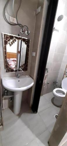 a bathroom with a sink and a toilet and a mirror at Mondy Pyramids Hotel in Cairo