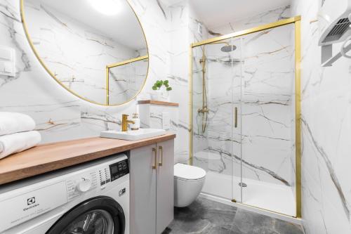 a bathroom with a washer and dryer and a mirror at APARTAMENTY MIERZEJA - STEGNA PARK II, MEDIUM, 500 m od plaży, Bezpłatny Meleks in Stegna