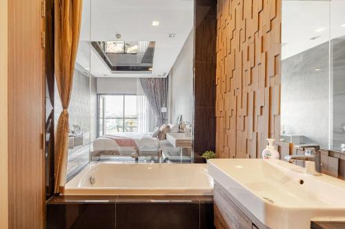a bathroom with a tub and a sink at Moda Condo Nimman 608 - Super Deluxe Mountain View next to MAYA in Chiang Mai