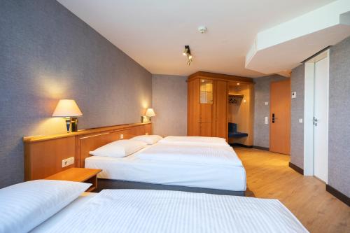 a room with three beds in a room at ACHAT Hotel Magdeburg in Magdeburg