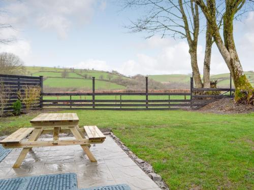 a picnic table in a field with a fence at Trefechan in Pumpsaint