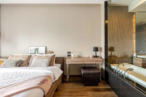 a bedroom with a bed and a desk and a bath tub at Moda Condo Nimman 608 - Super Deluxe Mountain View next to MAYA in Chiang Mai