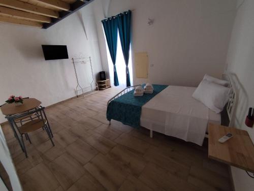 a bedroom with a bed and a table and a television at B&B Via Roma in Sannicola