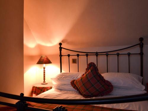 a bedroom with a bed with a pillow and a lamp at Vindolanda in Fearnmore