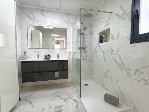 ein weißes Badezimmer mit Waschbecken und Dusche in der Unterkunft R-40-1 Perla Mediterranea in Lo Bigo