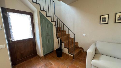 a living room with a staircase with a door and a couch at L'Angulìn in Vezzo