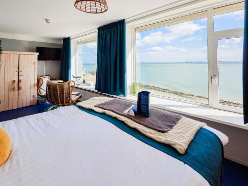 a bedroom with a bed with a view of the ocean at Belgische Loodsensociëteit in Vlissingen