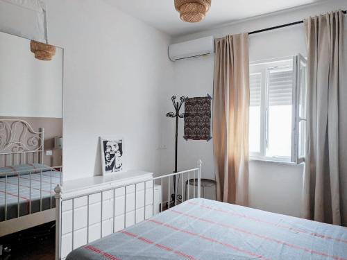 a white bedroom with a bed and a window at Attico vista mare con terrazza panoramica in Castellabate