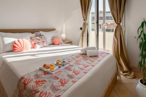 a hotel room with a bed with a tray of food on it at Villa Nymphaea Sperlongaresort in Sperlonga