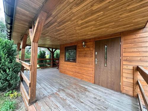 a wooden porch with a wooden door on a house at Noclegi na Szczęśliwej 1 w Okunince in Okuninka