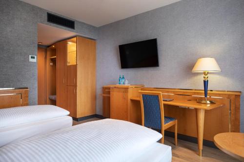 a hotel room with a desk and a bed and a desk sidx sidx sidx sidx at ACHAT Hotel Magdeburg in Magdeburg