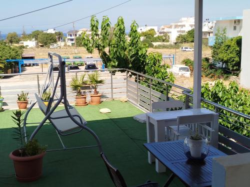 a patio with a table and chairs on a balcony at Garifalia Studios in Kalamaki Heraklion