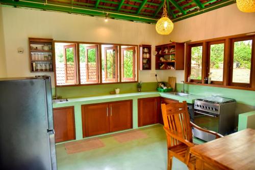 a kitchen with wooden cabinets and a stainless steel refrigerator at Villa Green Smile in Aluthgama