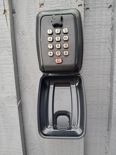 a black pay phone is attached to a door at Beinn View Pod in Corpach