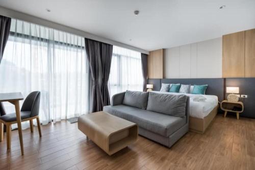 a living room with a bed and a couch at Wyndham Gardens Forrest View 1216 Studio in Nai Thon Beach