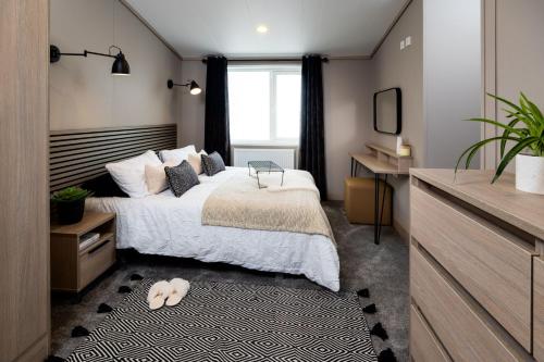 セント・アンドルーズにあるHot tub Lodge, Victory 101のベッドと机と窓のある寝室